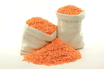 Image showing Red lentils in bags and on pile.  