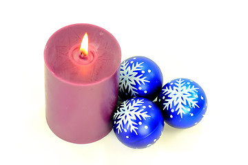 Image showing Purple Burning candle and blue decoration balls. 