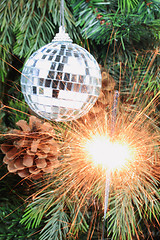 Image showing Christmas tree, mirror ball and lit sparkler. 