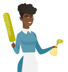 Image showing African housemaid holding spray bottle and duster.