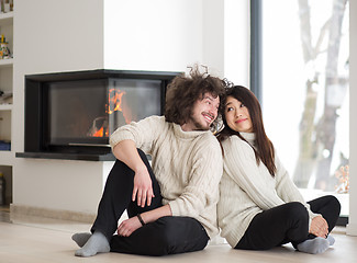 Image showing happy multiethnic couple  in front of fireplace