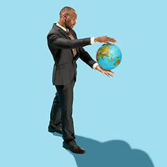 Image showing Businessman holding the world in the palm of hands concept for global business, communications, politics