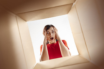 Image showing Woman unpacking and opening carton box and looking inside