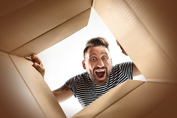 Image showing Man unpacking and opening carton box and looking inside