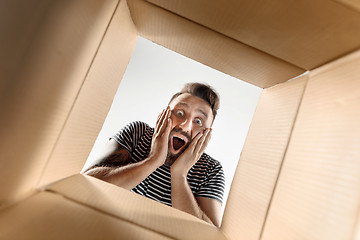 Image showing Man unpacking and opening carton box and looking inside