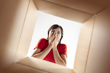 Image showing Woman unpacking and opening carton box and looking inside