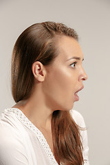 Image showing Beautiful woman looking suprised isolated on gray