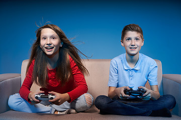 Image showing Computer game competition. Gaming concept. Excited girl playing video game with joystick