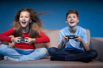 Image showing Computer game competition. Gaming concept. Excited girl playing video game with joystick