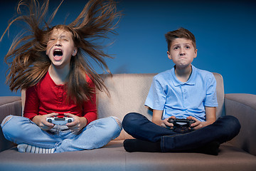 Image showing Computer game competition. Gaming concept. Excited girl playing video game with joystick