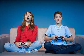 Image showing Computer game competition. Gaming concept. Excited girl playing video game with joystick