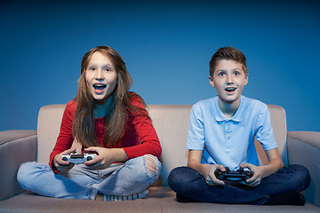 Image showing Computer game competition. Gaming concept. Excited girl playing video game with joystick