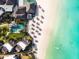 Image showing Aerial view of amazing tropical white sandy beach with palm leaves umbrellas and turquoise sea, Mauritius.