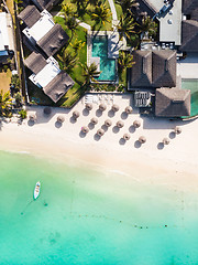 Image showing Aerial view of amazing tropical white sandy beach with palm leaves umbrellas and turquoise sea, Mauritius.