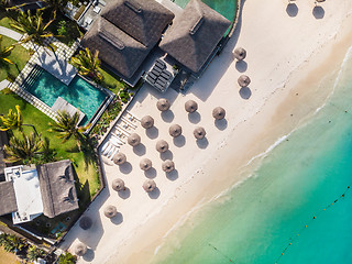 Image showing Aerial view of amazing tropical white sandy beach with palm leaves umbrellas and turquoise sea, Mauritius.