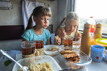 Image showing Two girls have lunch in the reserved seat of the train