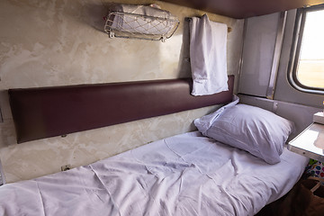 Image showing General view of the empty lower shelf of the reserved seat carriage of the train, spread bedding