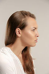 Image showing Portrait of an angry woman looking at camera isolated on a gray background