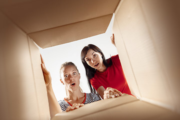 Image showing Women unpacking and opening carton box and looking inside