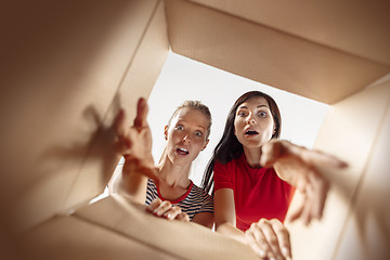 Image showing Women unpacking and opening carton box and looking inside