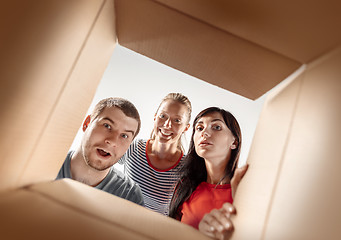 Image showing The people unpacking and opening carton box and looking inside