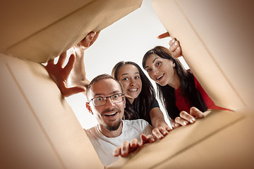 Image showing The people unpacking and opening carton box and looking inside