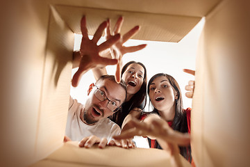 Image showing The people unpacking and opening carton box and looking inside