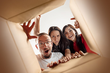 Image showing The people unpacking and opening carton box and looking inside