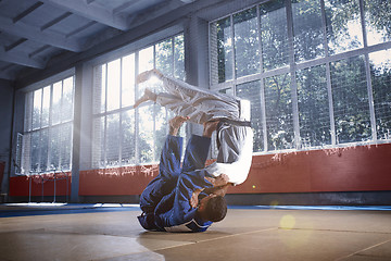 Image showing Two judo fighters showing technical skill while practicing martial arts in a fight club