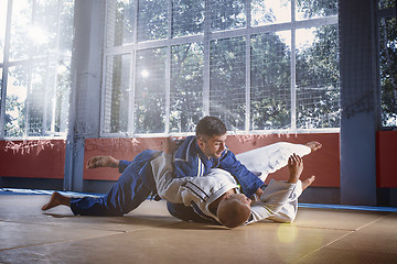 Image showing Two judo fighters showing technical skill while practicing martial arts in a fight club