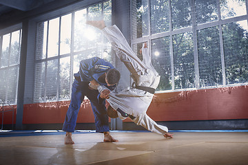 Image showing Two judo fighters showing technical skill while practicing martial arts in a fight club