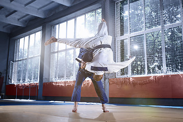 Image showing Two judo fighters showing technical skill while practicing martial arts in a fight club