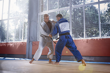 Image showing Two judo fighters showing technical skill while practicing martial arts in a fight club