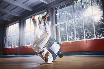 Image showing Two judo fighters showing technical skill while practicing martial arts in a fight club