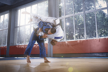 Image showing Two judo fighters showing technical skill while practicing martial arts in a fight club