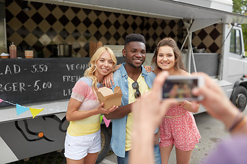 Image showing man taking picture of friends eating at food truck