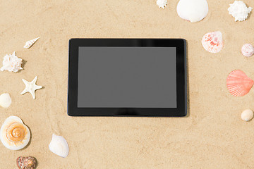 Image showing tablet computer and seashells on beach sand