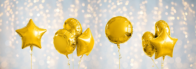 Image showing many metallic gold helium balloons on white