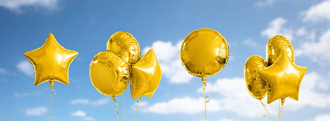 Image showing many metallic gold helium balloons on white