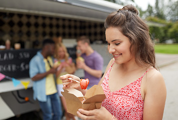 Image showing happy woman with wok and friends at food truck