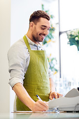 Image showing florist man or seller at flower shop counter