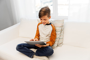 Image showing smiling boy with tablet pc computer at home