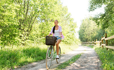 Image showing woman riding bicycle with basket at summer park