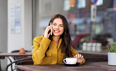 Image showing teenage girl calling on smartphone at city cafe