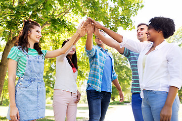 Image showing happy friends making high five in park