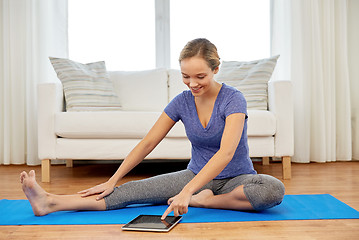 Image showing woman with tablet computer doing yoga at home