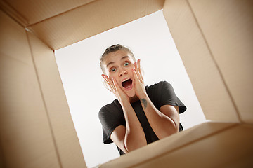 Image showing Woman unpacking and opening carton box and looking inside