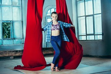 Image showing Graceful gymnast resting after performing aerial exercise at loft