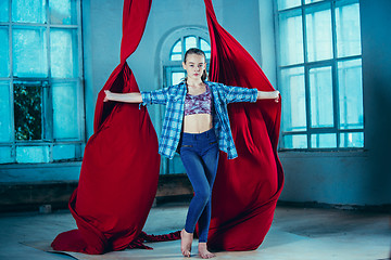 Image showing Graceful gymnast resting after performing aerial exercise at loft