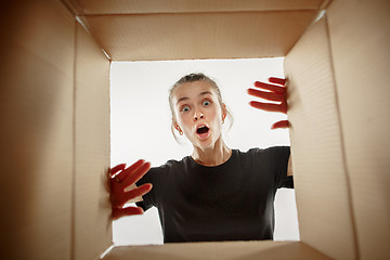 Image showing Woman unpacking and opening carton box and looking inside